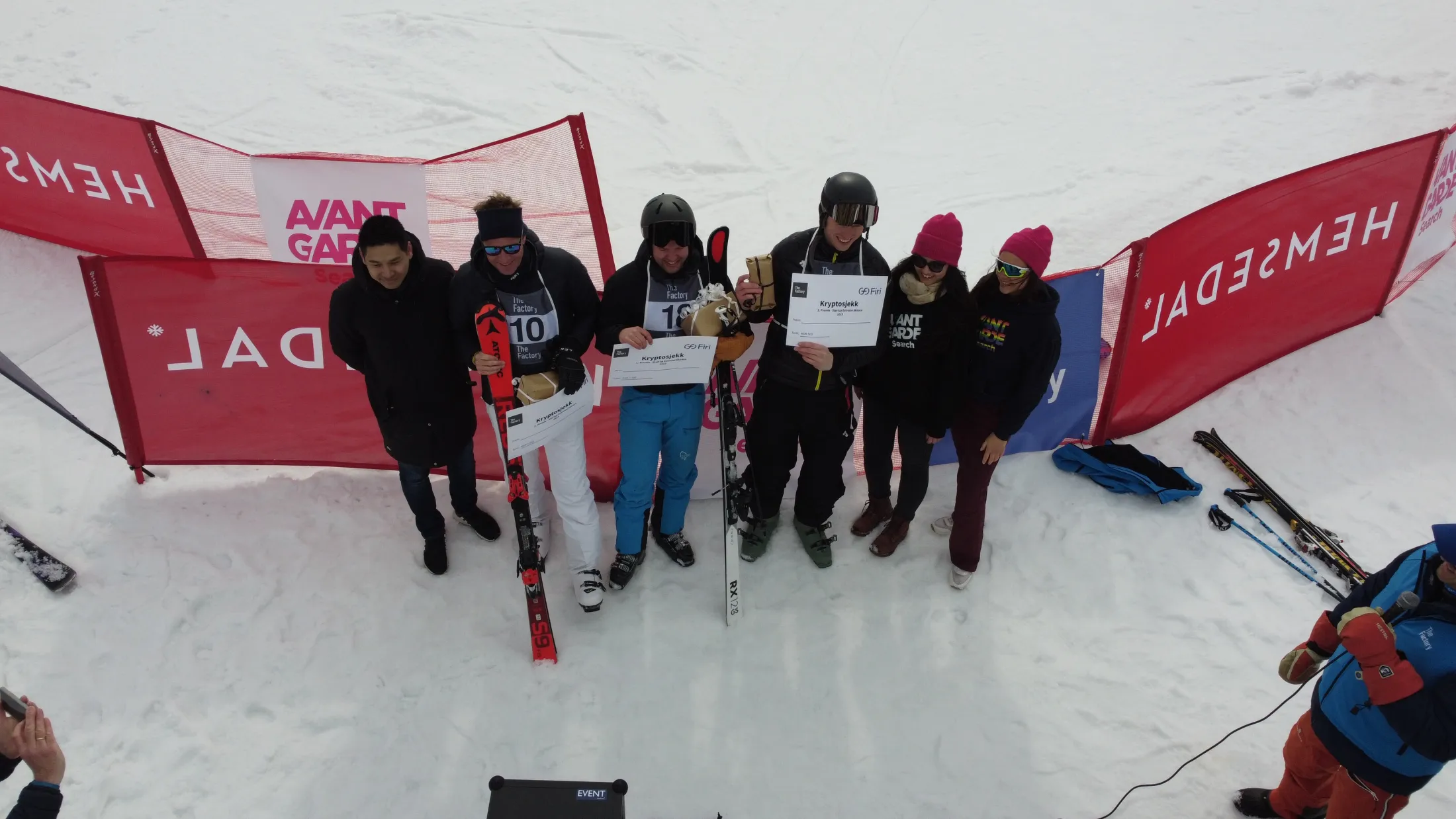 Drone view of the ski race finish area, racers with bib numbers between Hemsedal banners.